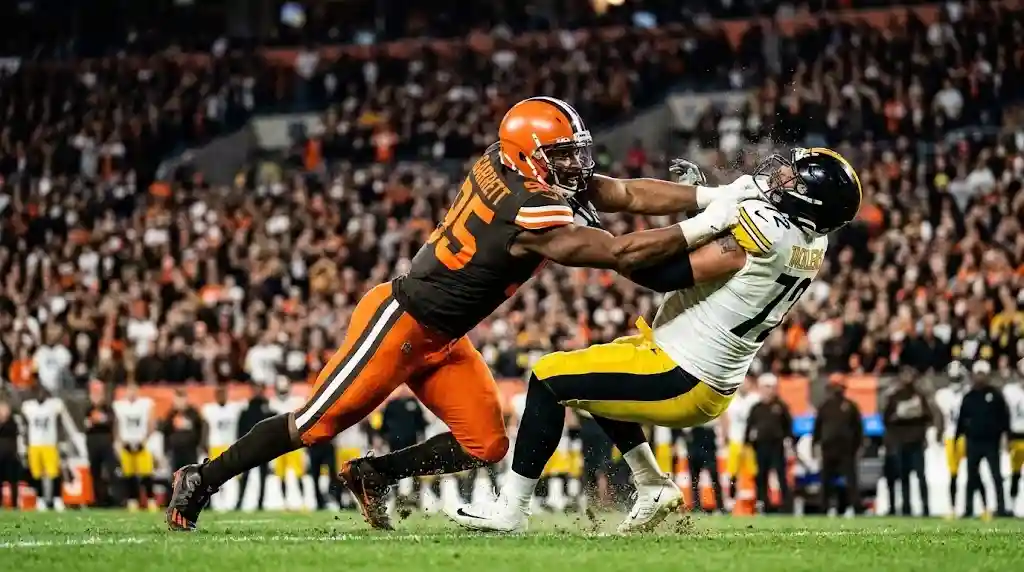 Myles Garrett sacks opposing offensive lineman during an intense Cleveland Browns NFL game.
